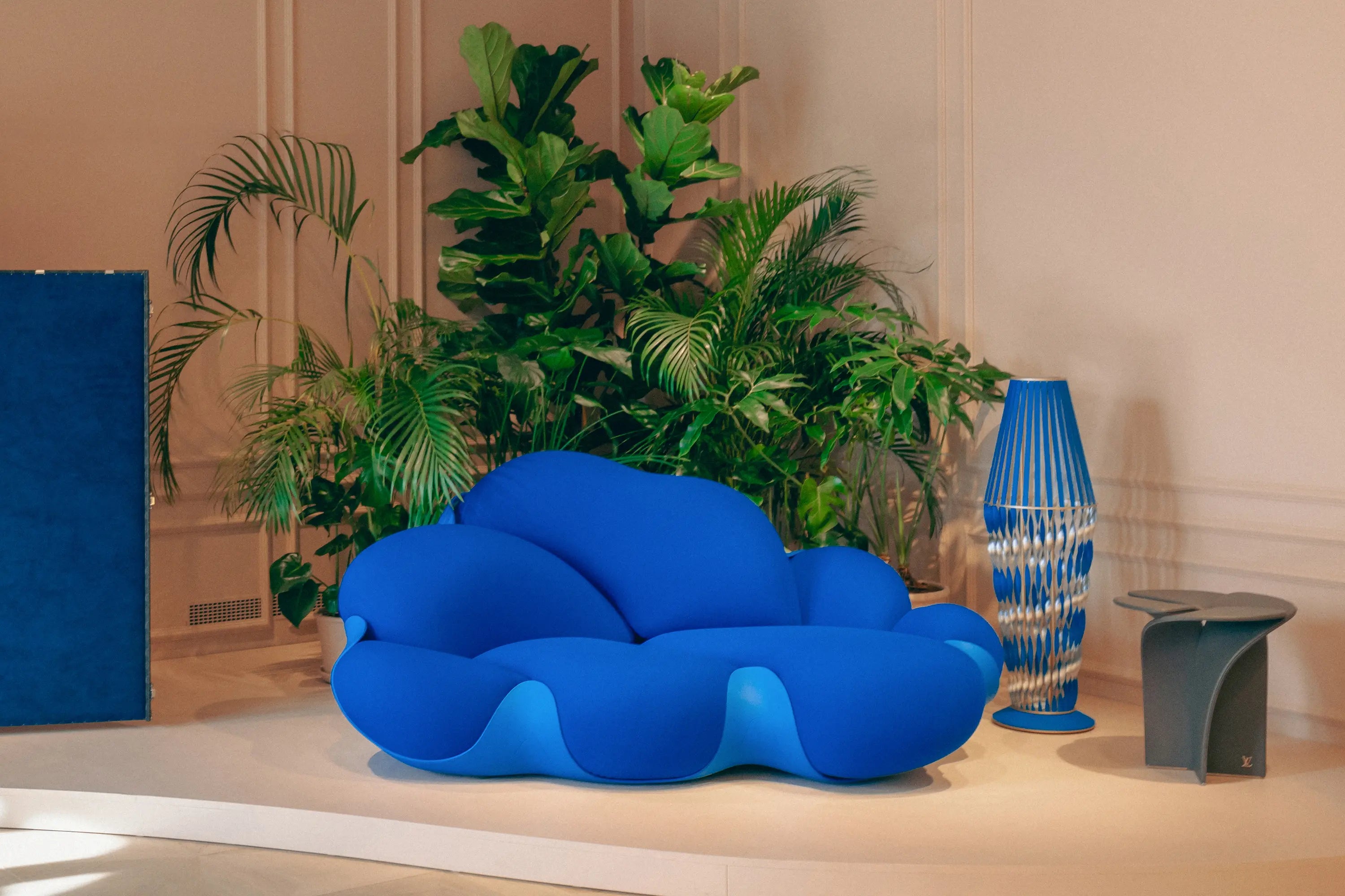 Innenraumbegrünung von Calienna für Louis Vuitton in Wien: skulpturales Sofa in Blau, umgeben von Ficus lyrata und weiterer Bepflanzung im Boutique-Interieur.